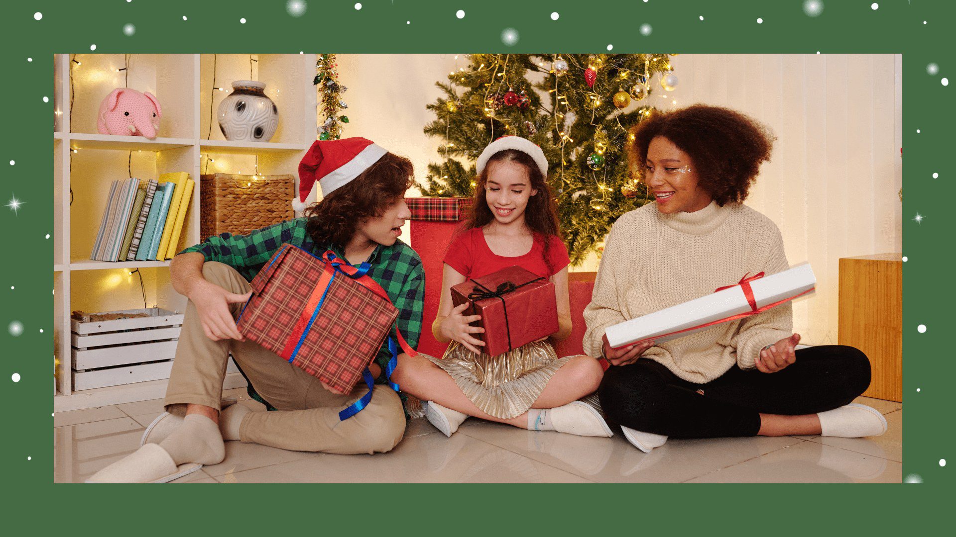 Three women sitting on the ground with christmas presents.