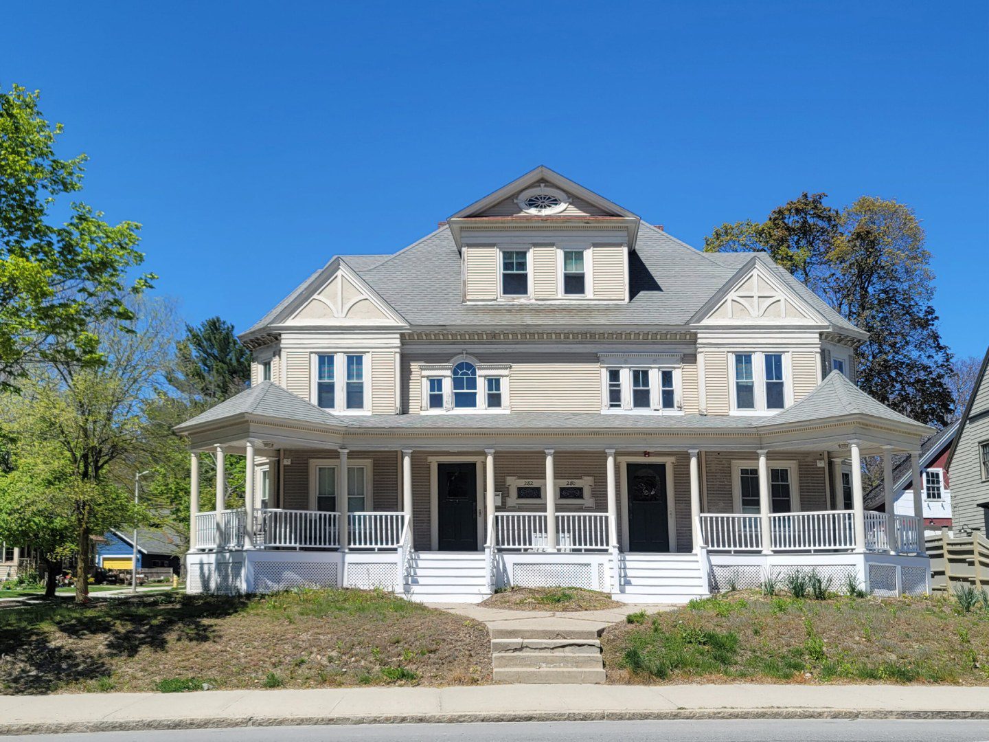 A large white house with a porch and steps.